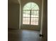 Bright living room featuring a large arched window and light wood-look flooring at 4220 Glad Morning Dr, College Park, GA 30349