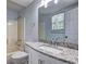 Bright bathroom with modern granite countertop, updated fixtures, and tub with tile surround at 476 Cody Ln, Douglasville, GA 30134