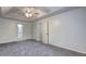 Spacious bedroom with tray ceiling, fan, and neutral carpeting, including ensuite bathroom at 476 Cody Ln, Douglasville, GA 30134
