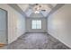 Spacious bedroom with tray ceiling, fan, and neutral carpeting at 476 Cody Ln, Douglasville, GA 30134