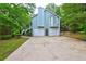 Exterior of home showing a three-car garage, a deck, and mature landscaping at 476 Cody Ln, Douglasville, GA 30134