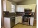 Well-equipped kitchen featuring stainless steel appliances, white cabinets, and granite counters at 5389 Martins Crossing Rd, Stone Mountain, GA 30088