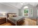 Cozy bedroom features hardwood floors, a ceiling fan, and backyard views at 2026 Cresthaven Walk, Woodstock, GA 30189
