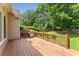 Wooden deck with railings and an outdoor grill, overlooking a lush backyard at 2026 Cresthaven Walk, Woodstock, GA 30189