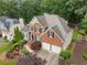 A stylish brick home featuring a two-car garage, manicured landscaping, green shutters, and a classic architectural design at 2026 Cresthaven Walk, Woodstock, GA 30189