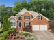 Beautiful two-story brick home with lush landscaping, a two-car garage, and dark green shutters at 2026 Cresthaven Walk, Woodstock, GA 30189