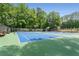 A community tennis court with two lit courts, surrounded by benches and lush trees at 2026 Cresthaven Walk, Woodstock, GA 30189