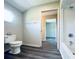 Bathroom featuring gray plank flooring, toilet, bathtub, and window for natural light at 238 Marks Rd, Mansfield, GA 30055