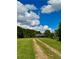 Long driveway leading to house on large grassy lot with a blue sky at 238 Marks Rd, Mansfield, GA 30055
