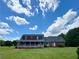 Charming red brick home with a covered porch, set on a spacious lawn under a sunny sky at 238 Marks Rd, Mansfield, GA 30055