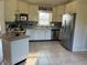 Bright kitchen with stainless steel appliances, white cabinetry, and tile flooring at 238 Marks Rd, Mansfield, GA 30055