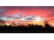Striking view of a vivid pink and orange sunset illuminating the sky above silhouetted trees at 238 Marks Rd, Mansfield, GA 30055
