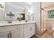 Bathroom featuring double sinks, modern fixtures, marble counters, and a glass shower at 2771 Smithsonia Way, Tucker, GA 30084