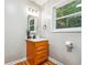 Stylish bathroom featuring a wood vanity, framed mirror, modern fixtures, and natural light at 2771 Smithsonia Way, Tucker, GA 30084