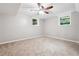 Cozy bedroom with neutral walls, carpet, ceiling fan, and natural light from two windows at 2771 Smithsonia Way, Tucker, GA 30084