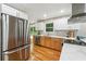 Well-lit kitchen features stainless steel refrigerator and modern appliances, and view to deck at 2771 Smithsonia Way, Tucker, GA 30084