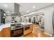 Open-concept kitchen features island cooktop and flows into naturally lit living and dining area at 2771 Smithsonia Way, Tucker, GA 30084