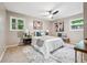 Comfortable main bedroom with a ceiling fan, stylish decor, and windows overlooking the surrounding greenery at 2771 Smithsonia Way, Tucker, GA 30084