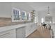 A bright kitchen featuring white cabinets, countertops, modern appliances, and stainless steel sink at 343 Sugarview Rd, Sugar Hill, GA 30518
