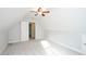 Attic bonus room with soft gray carpeting, neutral walls, ceiling fan and bright white door to the utility closet at 410 Hendon Rd, Woodstock, GA 30188