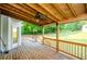 Relax on this wooden back porch with wooden railing overlooking the spacious, grassy backyard at 410 Hendon Rd, Woodstock, GA 30188
