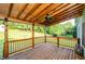 Enjoy backyard views from this back porch with wood railing, a ceiling fan and tongue-and-groove ceiling at 410 Hendon Rd, Woodstock, GA 30188