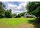 Large backyard with a white fence and trees offers plenty of open space at 410 Hendon Rd, Woodstock, GA 30188