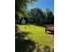 The large grassy backyard with a shed and the corner of a wooden deck at 410 Hendon Rd, Woodstock, GA 30188