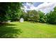 Sprawling green backyard with a white barn and a line of trees at the edge of the yard at 410 Hendon Rd, Woodstock, GA 30188