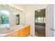Bright bathroom features a double vanity, large mirror with lighting, and an entrance to the bedroom at 410 Hendon Rd, Woodstock, GA 30188