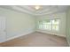 Spacious bedroom featuring a tray ceiling, neutral carpeting, and window shutters at 410 Hendon Rd, Woodstock, GA 30188