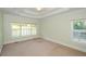 Spacious bedroom with a tray ceiling, neutral carpeting, and bright windows at 410 Hendon Rd, Woodstock, GA 30188