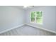 Cozy bedroom with soft gray carpet and view from the large window overlooking the green backyard at 410 Hendon Rd, Woodstock, GA 30188