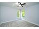 This bedroom features plush gray carpeting, a modern ceiling fan, and natural light from the double-hung windows at 410 Hendon Rd, Woodstock, GA 30188