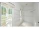 Bright walk-in closet with shelving, a window overlooking the front porch, and tile flooring at 410 Hendon Rd, Woodstock, GA 30188