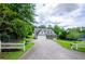 Scenic home featuring a long driveway, two-car garage, and inviting front porch, all surrounded by lush trees at 410 Hendon Rd, Woodstock, GA 30188