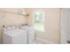Practical laundry room with white appliances and ample natural light from a window at 410 Hendon Rd, Woodstock, GA 30188