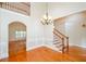Open-concept living room with hardwood floors, wainscoting, chandelier, and staircase at 410 Hendon Rd, Woodstock, GA 30188