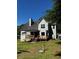Home's rear elevation with spacious deck and stairs leading to the backyard and large mature trees at 410 Hendon Rd, Woodstock, GA 30188