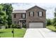 Charming two-story brick home featuring a well-maintained front yard, attached garage, and traditional design at 8553 Braylen Manor Dr, Douglasville, GA 30134