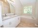 Bright bathroom features double vanity, soaking tub, and natural light at 10074 Tara Glynn Dr, Hampton, GA 30228