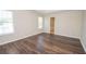 Large bedroom with neutral walls, wood floors, and natural light from two windows at 10074 Tara Glynn Dr, Hampton, GA 30228