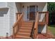 Inviting front entrance featuring wooden stairs and railing leading up to a glass-paneled door at 10074 Tara Glynn Dr, Hampton, GA 30228