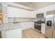 A modern kitchen features stainless steel appliances, white cabinets, granite countertops, and tile flooring at 10074 Tara Glynn Dr, Hampton, GA 30228