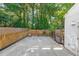 Fenced backyard with large concrete patio, greenery, and access gate at 10900 Wittenridge Dr # C7, Alpharetta, GA 30022
