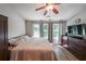 Cozy bedroom with hardwood floors, a ceiling fan, and large windows providing natural light at 10900 Wittenridge Dr # C7, Alpharetta, GA 30022