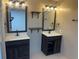 Dual vanity bathroom featuring dark cabinetry, large mirrors, modern lighting, and neutral tones at 1321 Earle Se Ct, Conyers, GA 30013