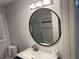 Modern bathroom featuring a new vanity, a stylish, round mirror, and neutral toned walls at 1321 Earle Se Ct, Conyers, GA 30013