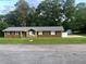 Inviting brick home featuring a stone facade, manicured lawn, and a shed, creating a serene outdoor space at 1321 Earle Se Ct, Conyers, GA 30013