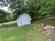 Outdoor shed in a grassy yard with a gray exterior and white trim at 1321 Earle Se Ct, Conyers, GA 30013